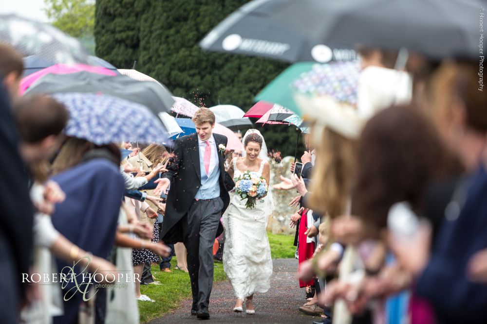 Creative wedding photographers Surrey Guests throwing confetti at bride and groom on wedding day in Surrey