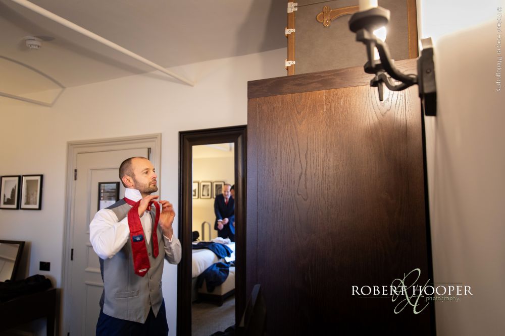 Groom putting on tie